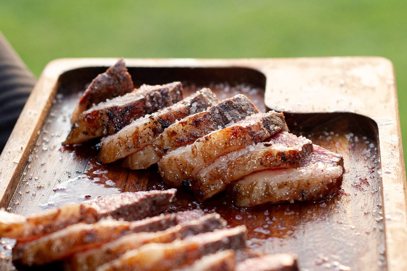 Picanha fatiada com sal grosso servida em tábua de madeira em evento