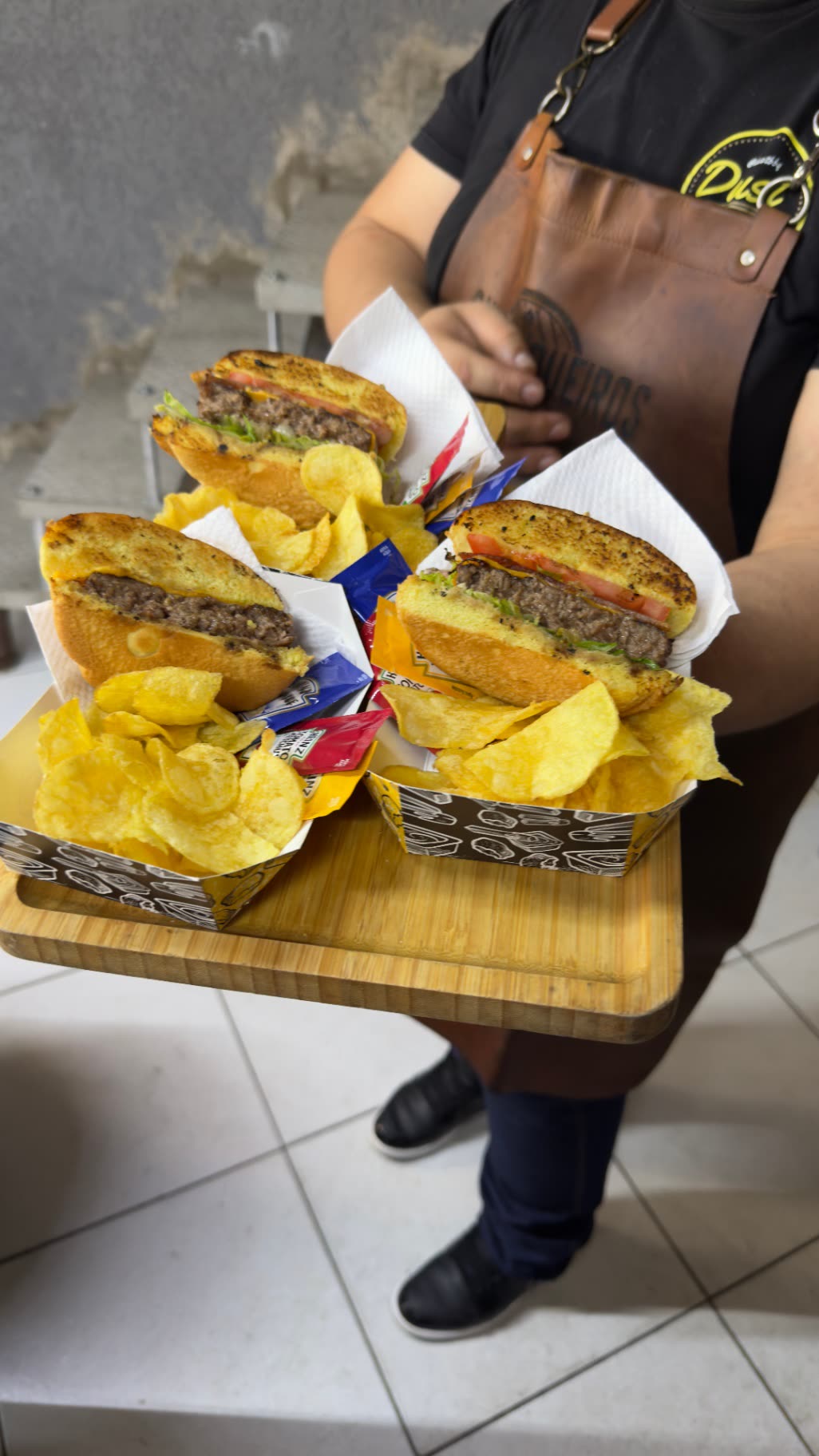 Bandeja com hambúrgueres artesanais e batatas servidos em evento