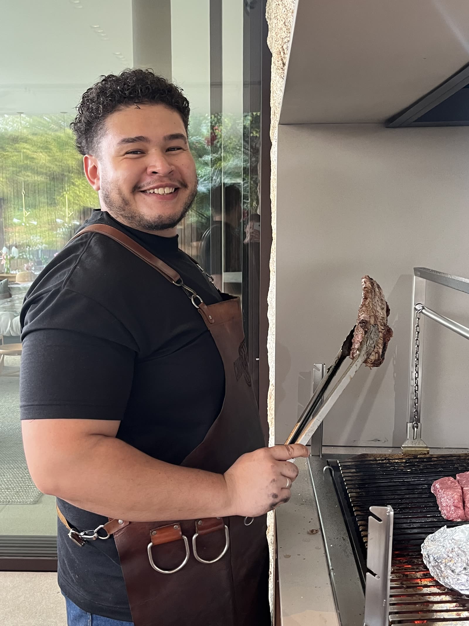 Assador da Dust preparando cortes na parrilla durante um evento